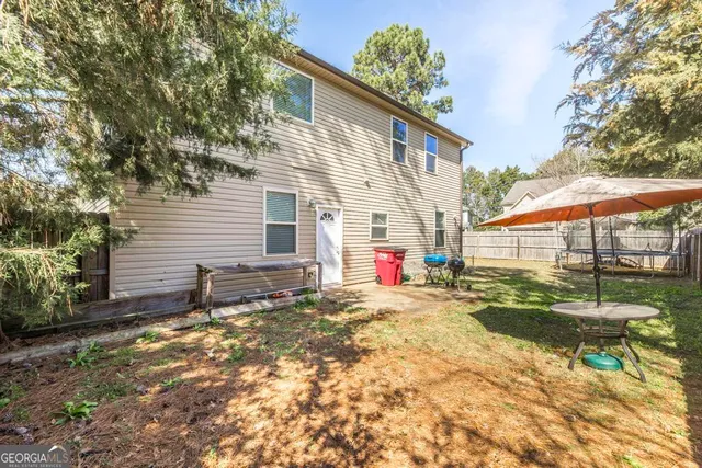 a view of a house with a backyard and a tree