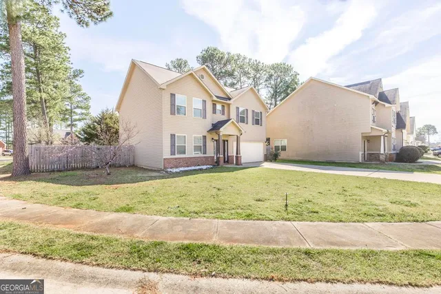 a view of a house with a yard and fence