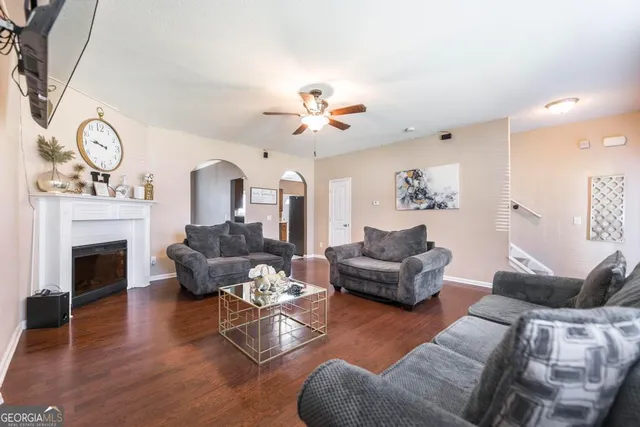 a living room with furniture a fireplace and a chandelier