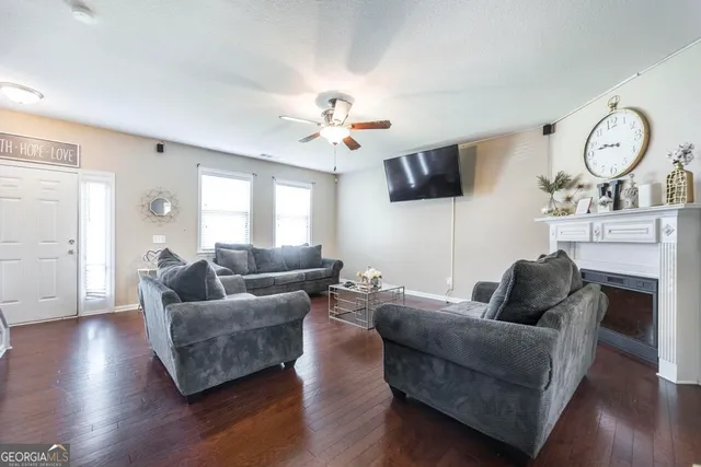 a living room with furniture a large window and a fireplace