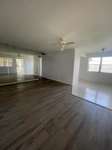 an empty room with wooden floor and window