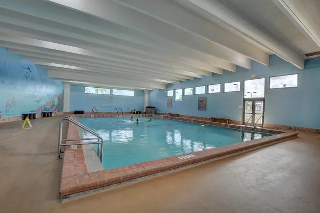 a large white kitchen with lots of counter space and chandelier