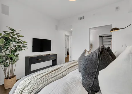 a bedroom with a bed and a flat screen tv
