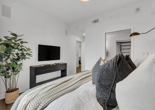 a bedroom with a bed and a flat screen tv