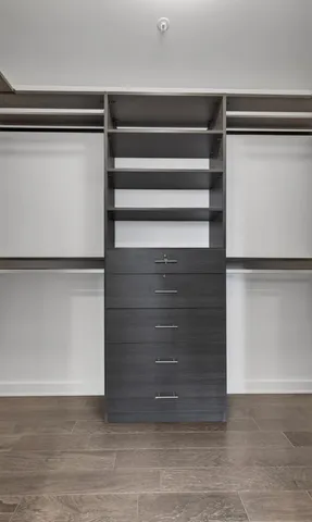 a view of walk in closet with empty racks