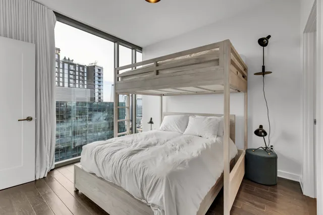 a bedroom with a bed and a large window