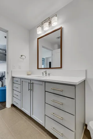 a bathroom with a sink vanity and mirror