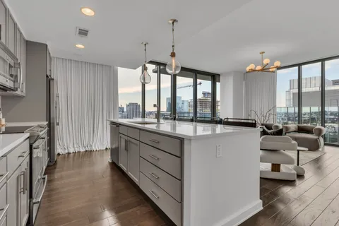 a large kitchen with kitchen island granite countertop a large window