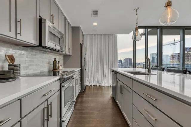 a kitchen with stainless steel appliances granite countertop a sink a stove and cabinets