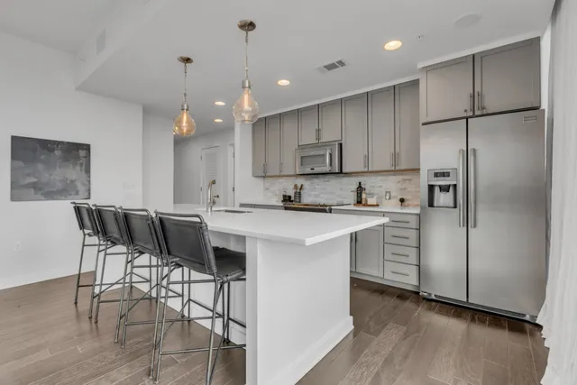 a kitchen with kitchen island granite countertop wooden floors and white cabinets