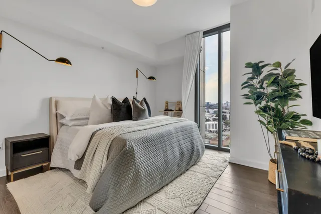 a bedroom with a large bed and a potted plant