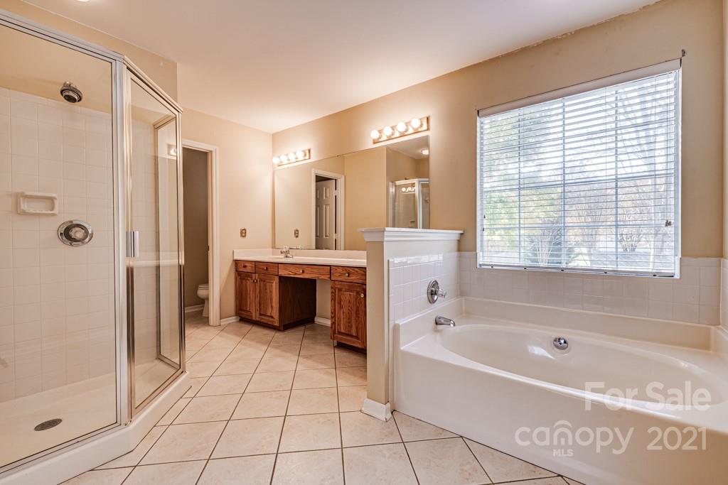 4511 Brownes Ferry Road Charlotte, NC 28269 - Photo 13 of 26 a spacious bathroom with a tub shower vanity and a sink