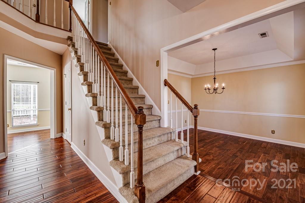 4511 Brownes Ferry Road Charlotte, NC 28269 - Photo 4 of 26 a view of staircase with wooden floor and white walls
