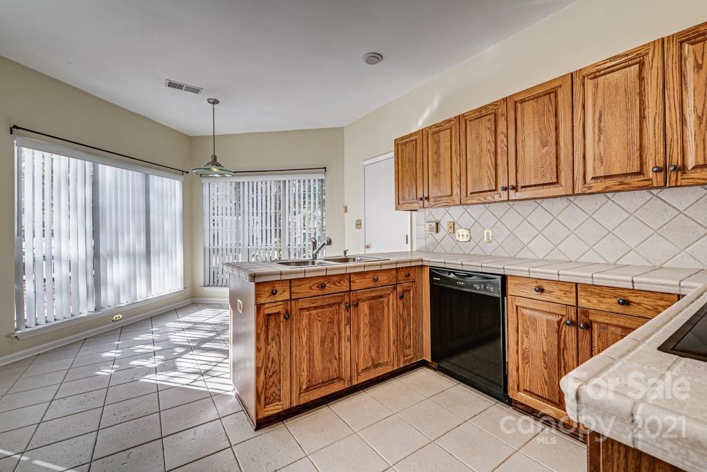 4511 Brownes Ferry Road Charlotte, NC 28269 - Photo 6 of 26 a kitchen with stainless steel appliances granite countertop a stove a sink dishwasher and a refrigerator with wooden cabinets