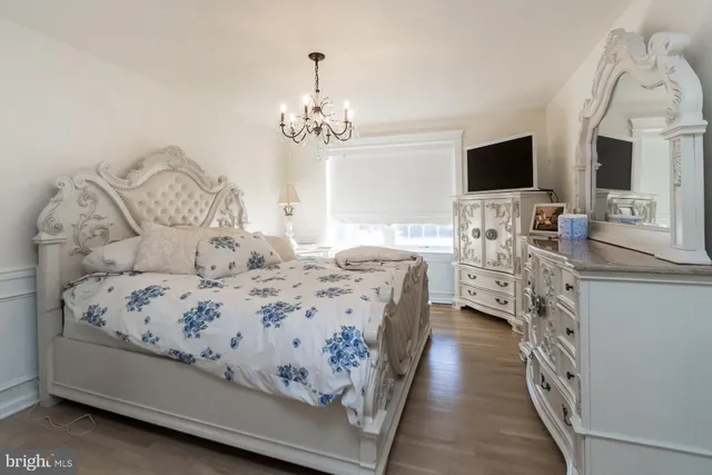 a bedroom with a chandelier and a dresser