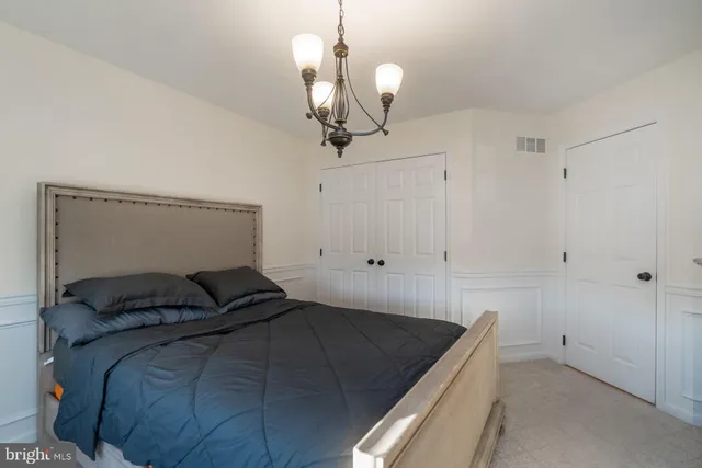 a view of a room with a chandelier and wooden floor