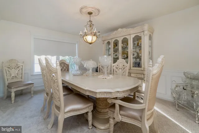 a very nice looking dining room with furniture a chandelier and wooden floor