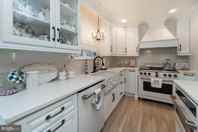 a kitchen with white cabinets and sink