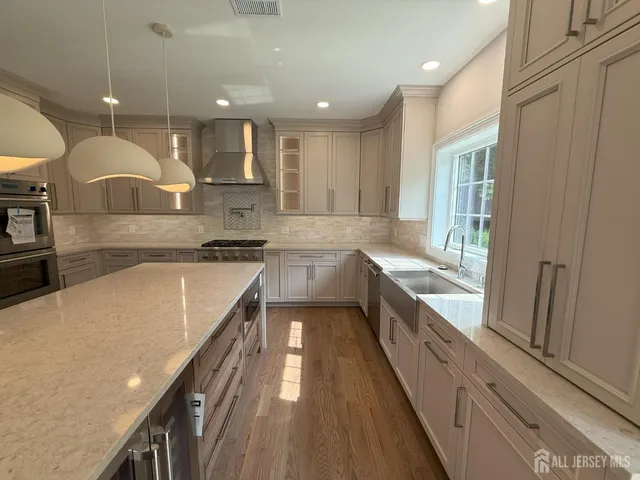 a kitchen with stainless steel appliances a stove a sink and a refrigerator