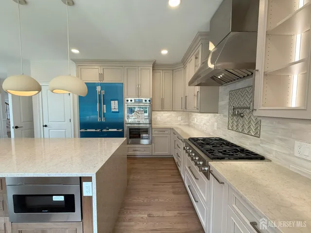 a kitchen with granite countertop a stove oven and white cabinets