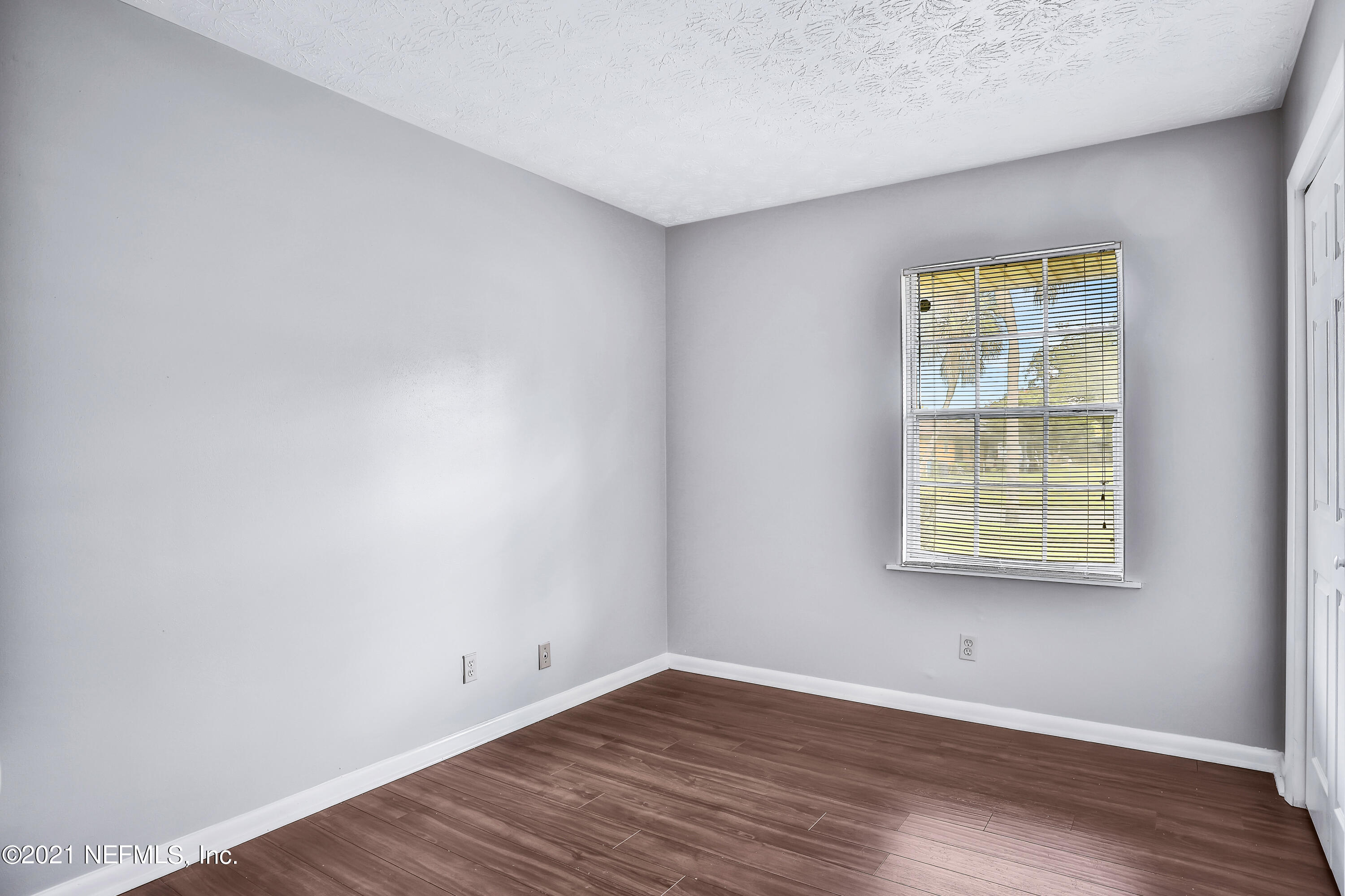1212 Bacall Road Jacksonville, FL 32218 - Photo 20 of 23 an empty room with wooden floor and windows