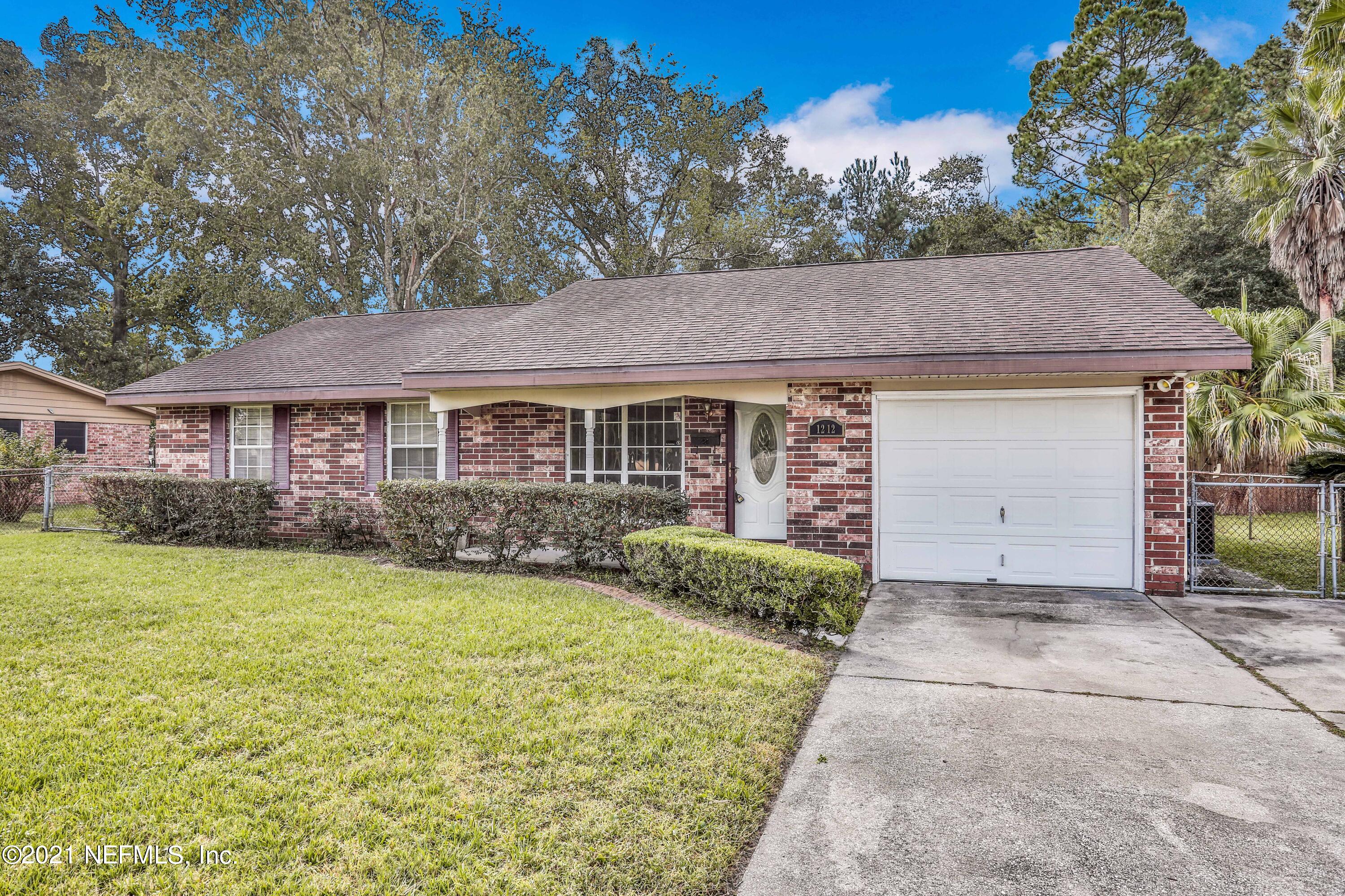 1212 Bacall Road Jacksonville, FL 32218 - Photo 2 of 23 a front view of a house with a garden and yard