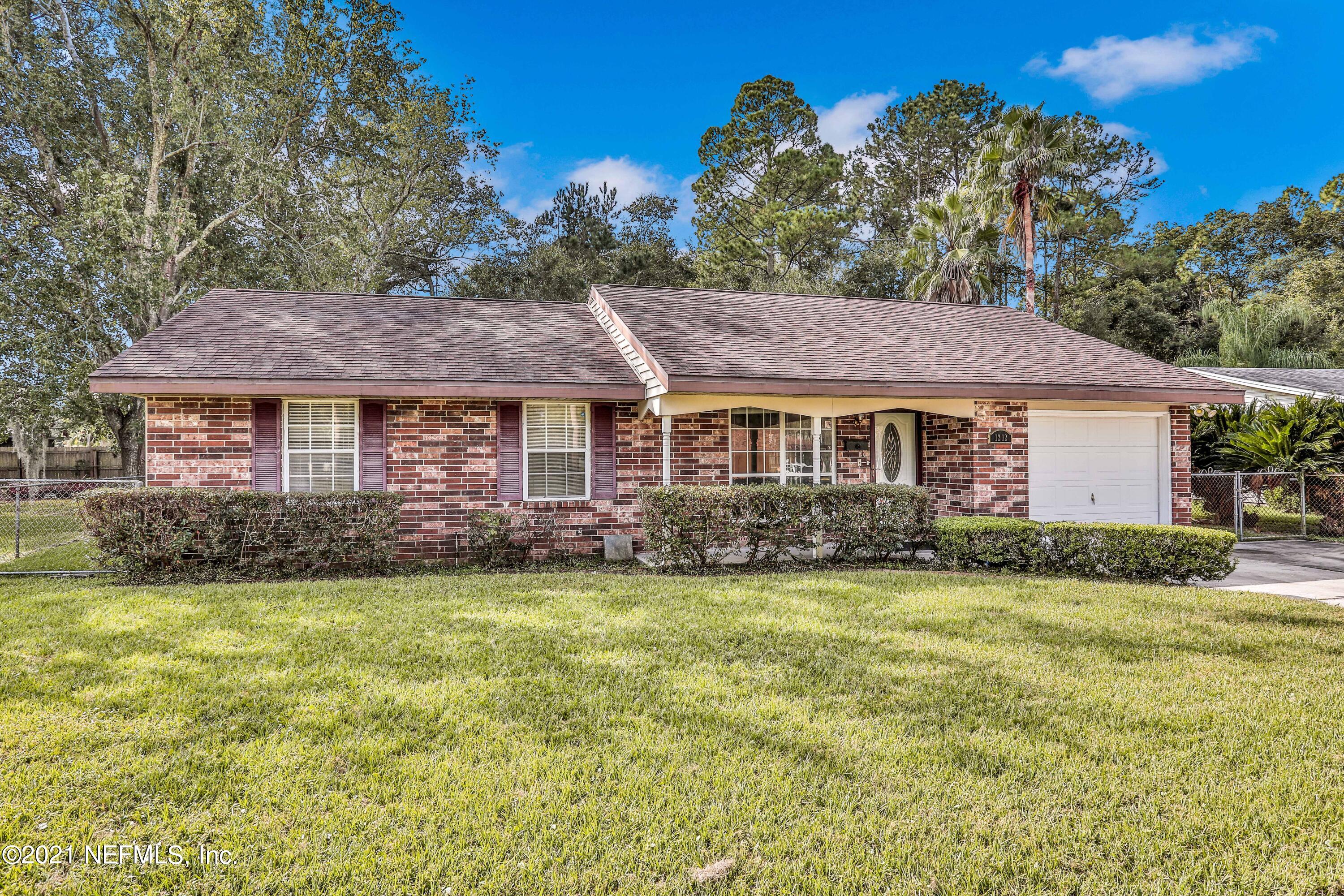 1212 Bacall Road Jacksonville, FL 32218 - Photo 3 of 23 a front view of a house with a garden and yard