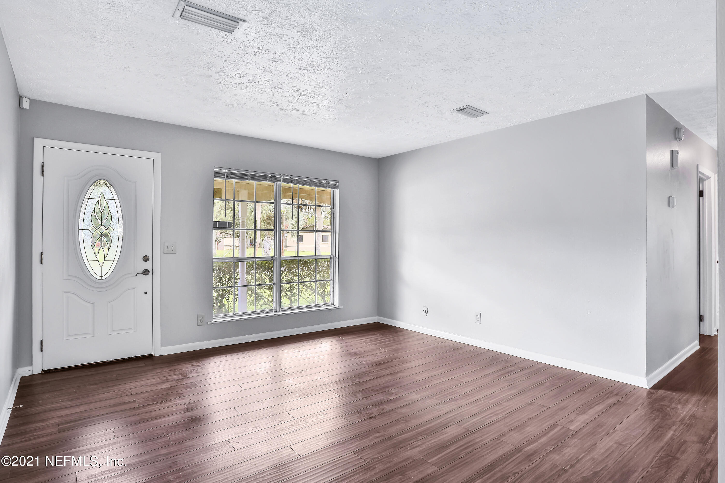 1212 Bacall Road Jacksonville, FL 32218 - Photo 4 of 23 an empty room with wooden floor and window