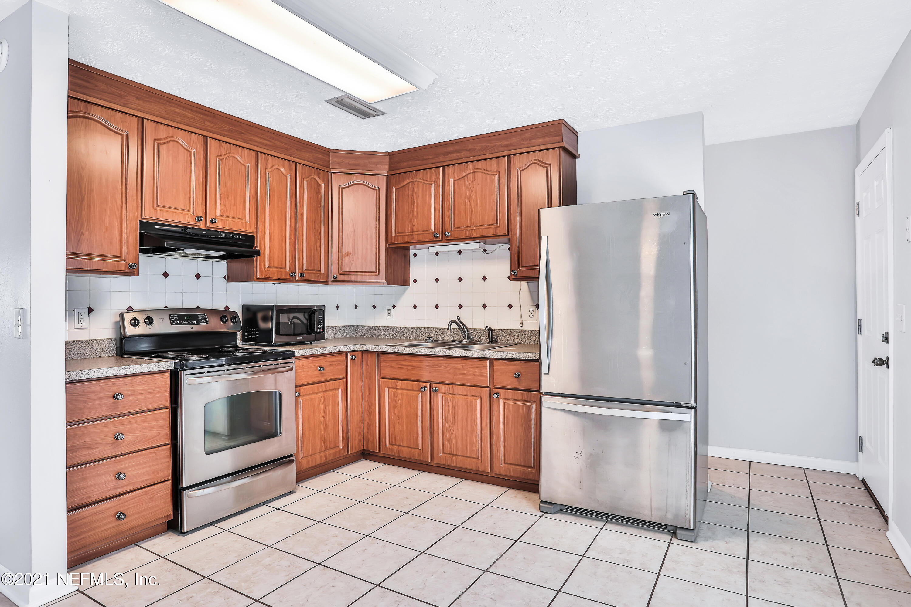 1212 Bacall Road Jacksonville, FL 32218 - Photo 8 of 23 a kitchen with stainless steel appliances granite countertop a refrigerator sink and cabinets