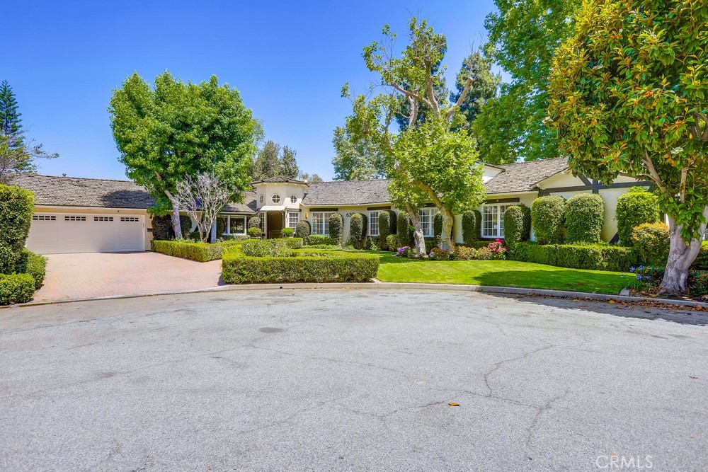 a view of a house with a big yard and large trees