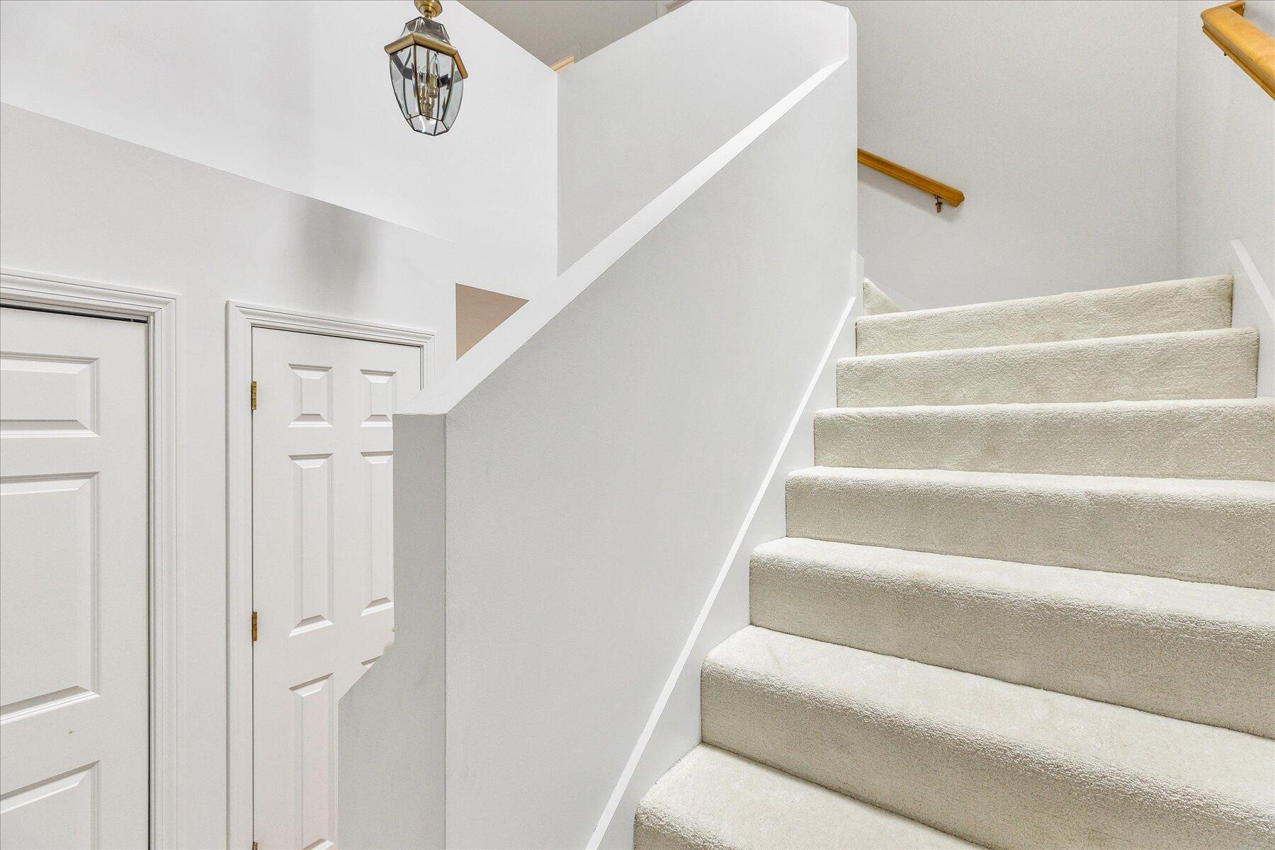 9 Red Cedar Road, Unit 9 Mashpee, MA 02649 - Photo 18 of 29 a view of staircase with white walls and a chandelier