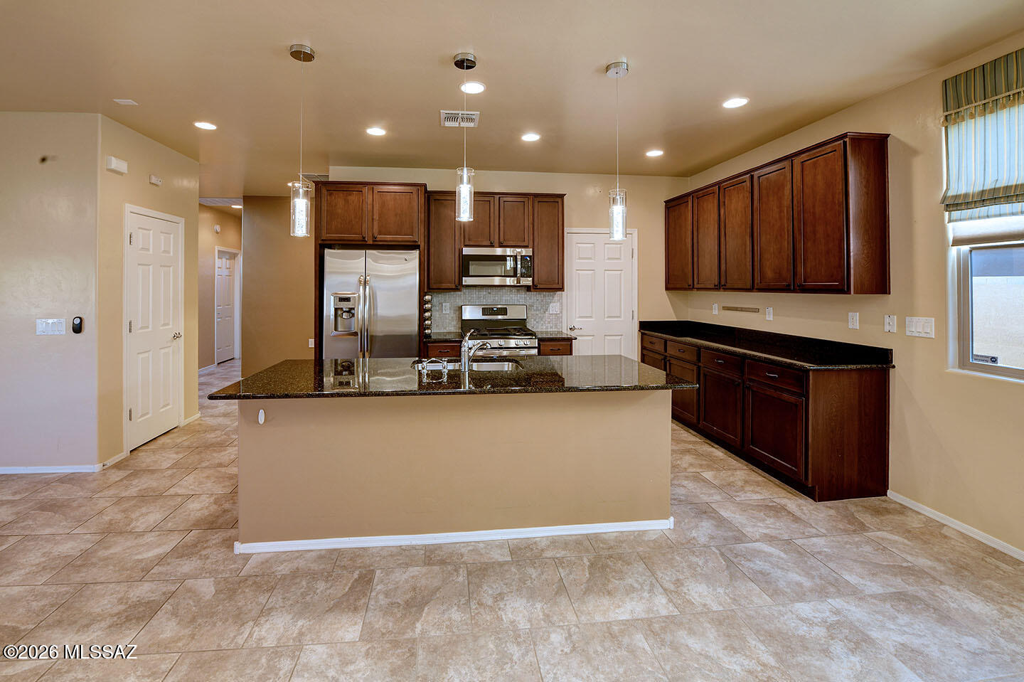 13991 East Cheavront Loop Vail, AZ 85641 - Photo 9 of 47 a large kitchen with stainless steel appliances granite countertop a large counter top and a stove
