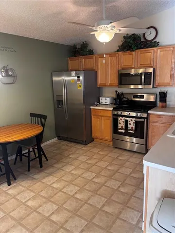 a kitchen with stainless steel appliances granite countertop a stove a sink and a refrigerator