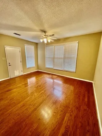 an empty room with a fireplace and a ceiling fan