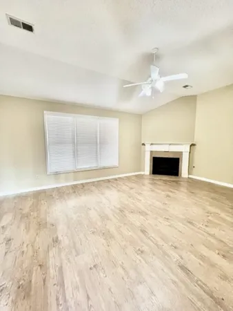 an empty room with a window and a ceiling fan