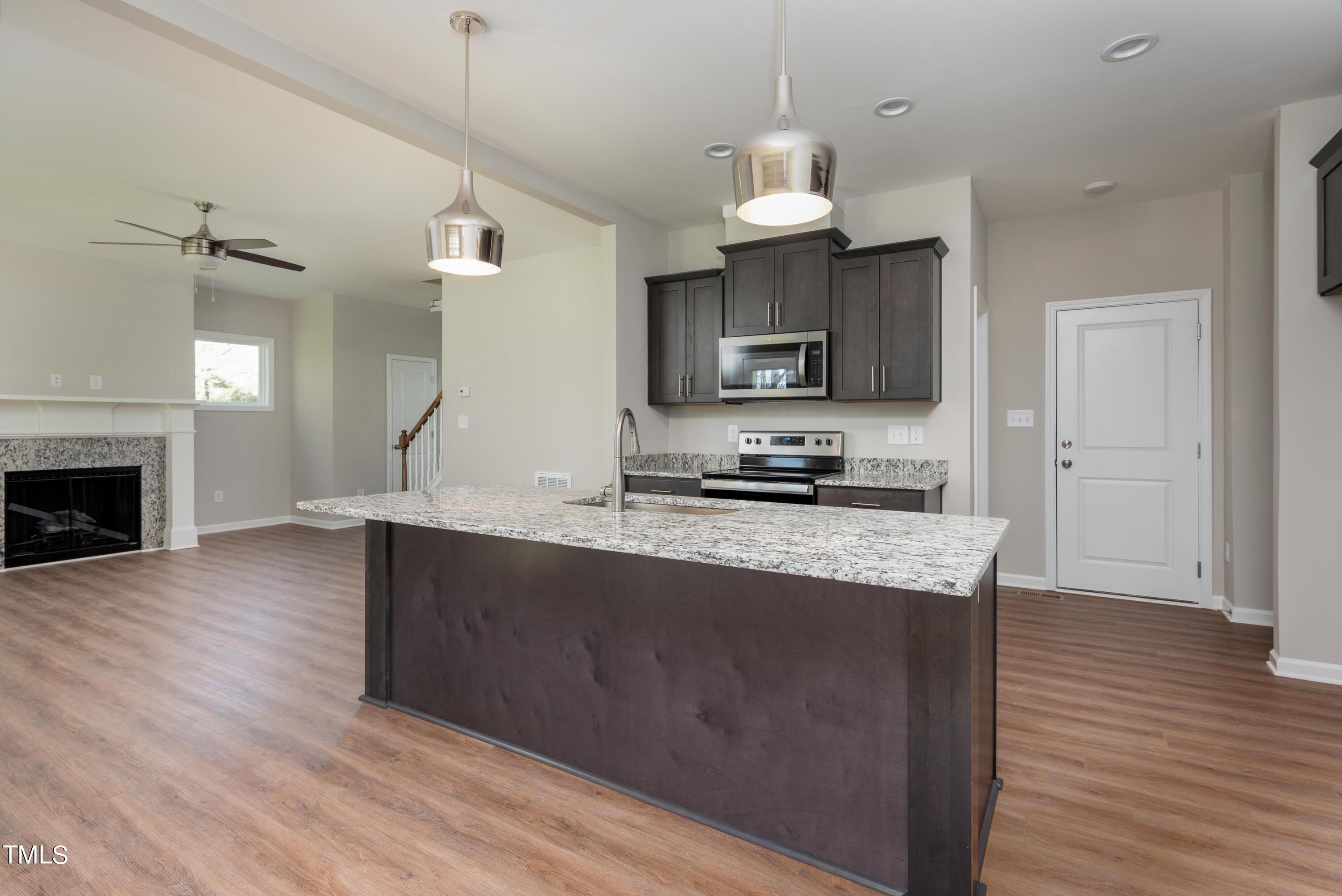 5080 Frazier Road Middlesex, NC 27557 - Photo 7 of 39 a kitchen with kitchen island granite countertop a sink stainless steel appliances and wooden floor