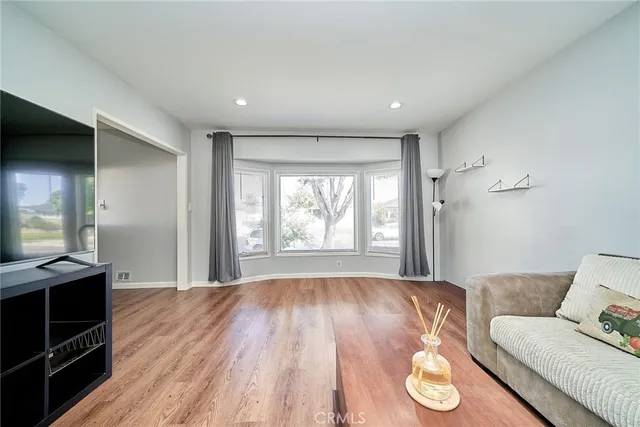 a kitchen with stainless steel appliances granite countertop wooden floor window and cabinets