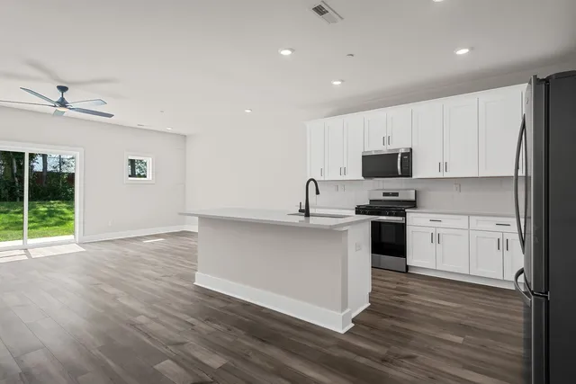 a kitchen with stainless steel appliances white cabinets and a refrigerator