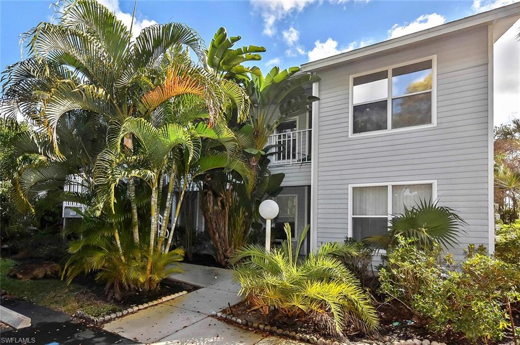 1895 Courtyard Way, Unit B103 Naples, FL 34112 - Photo 1 of 32 a plant is in front of a house