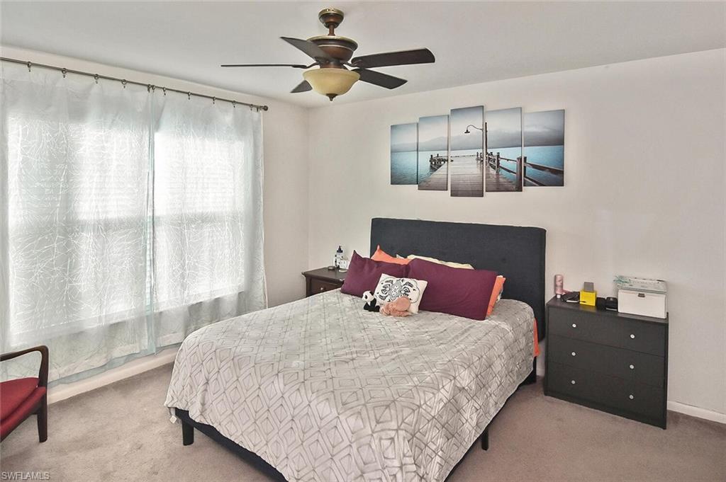 1895 Courtyard Way, Unit B103 Naples, FL 34112 - Photo 12 of 32 a bedroom with a large bed and a window