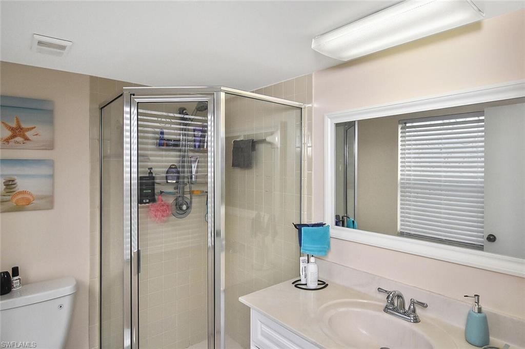 1895 Courtyard Way, Unit B103 Naples, FL 34112 - Photo 15 of 32 a bathroom with a sink and a mirror