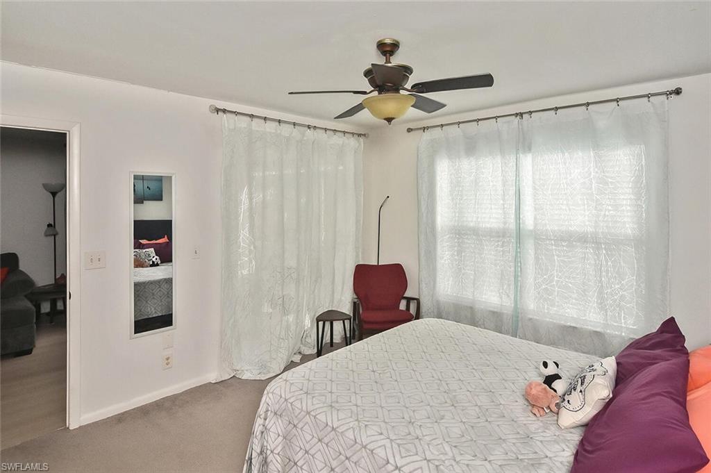 1895 Courtyard Way, Unit B103 Naples, FL 34112 - Photo 16 of 32 a bedroom with a bed and a window