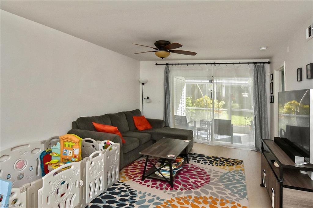 1895 Courtyard Way, Unit B103 Naples, FL 34112 - Photo 24 of 32 a living room with furniture and a flat screen tv