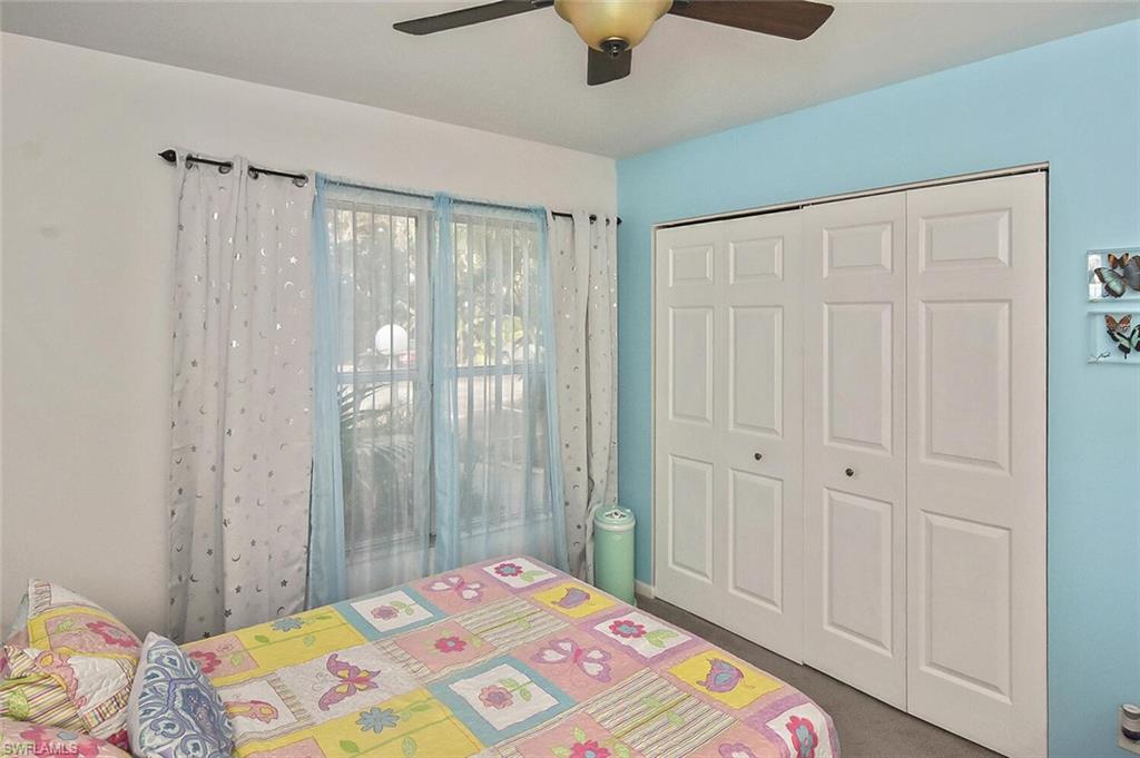 1895 Courtyard Way, Unit B103 Naples, FL 34112 - Photo 28 of 32 a bedroom with a bed and a window