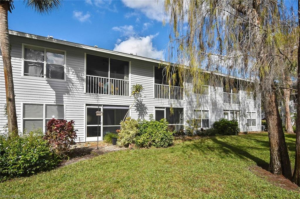 1895 Courtyard Way, Unit B103 Naples, FL 34112 - Photo 3 of 32 a view of a house with a yard