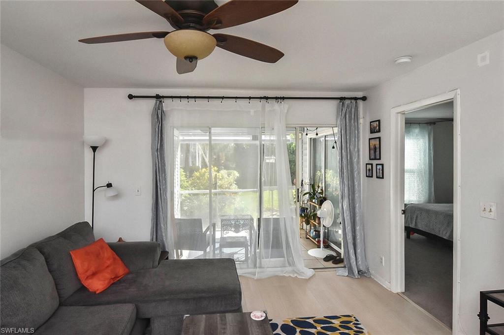 1895 Courtyard Way, Unit B103 Naples, FL 34112 - Photo 6 of 32 a living room with furniture and a floor to ceiling window