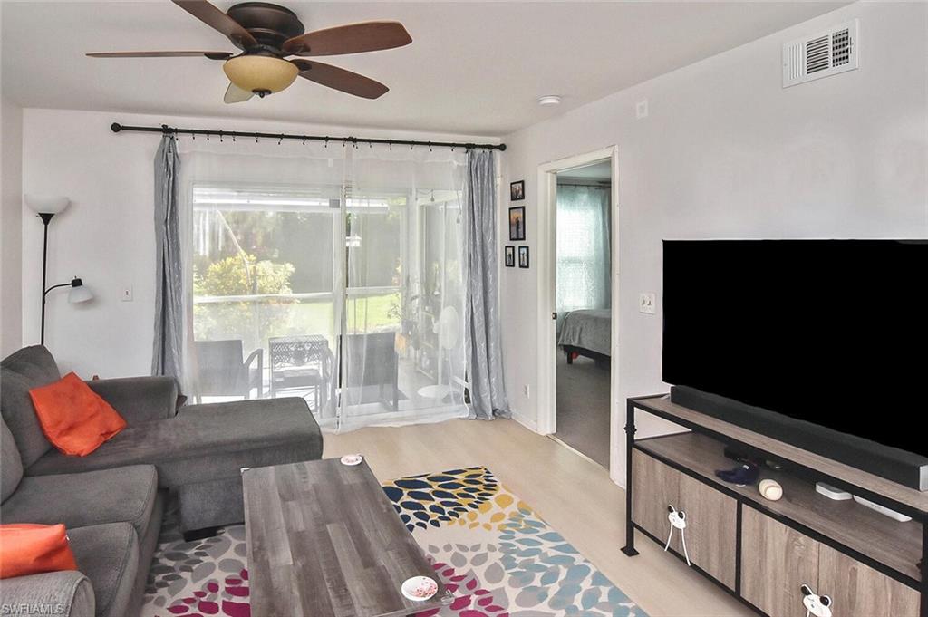1895 Courtyard Way, Unit B103 Naples, FL 34112 - Photo 9 of 32 a living room with furniture and a flat screen tv