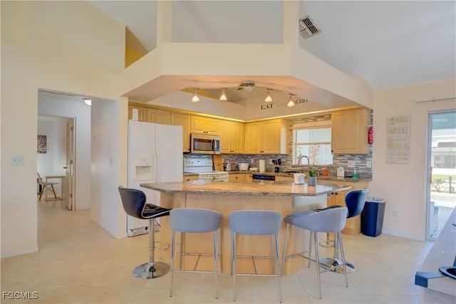 a kitchen with a sink and chairs