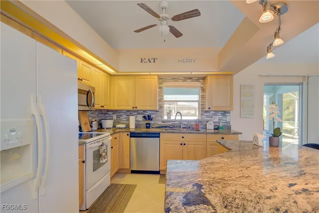 a large kitchen with a stove a sink dishwasher and a refrigerator