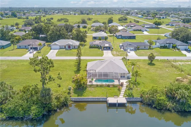 an aerial view of residential houses with outdoor space and lake view